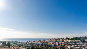 A coastal cityscape with a dense cluster of buildings, a clear sky, and the sea in the background. - Niko's Sea View Apartment (Dubrovnik)