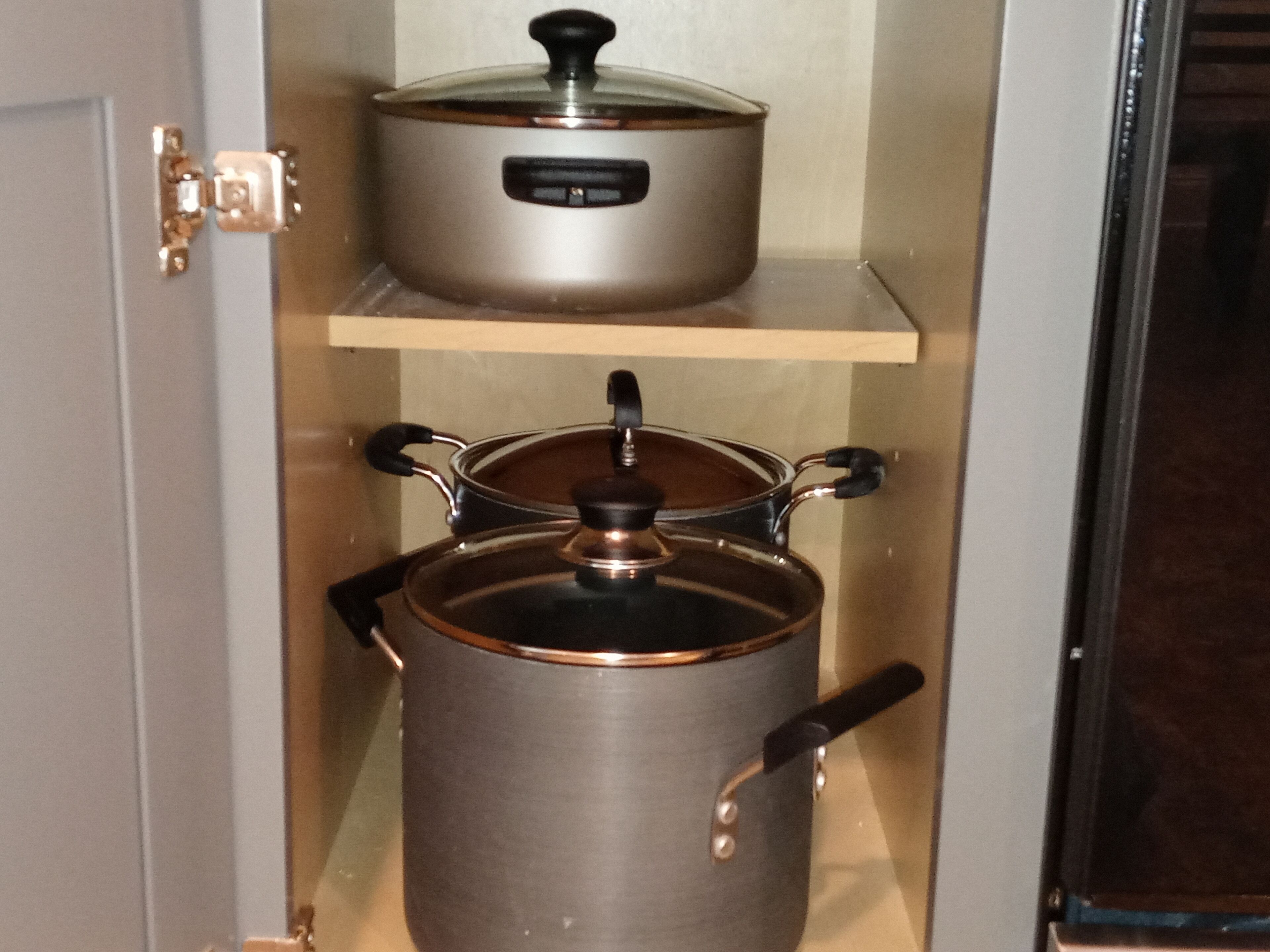 Una cucina con un fornello e due pentole sul bancone.