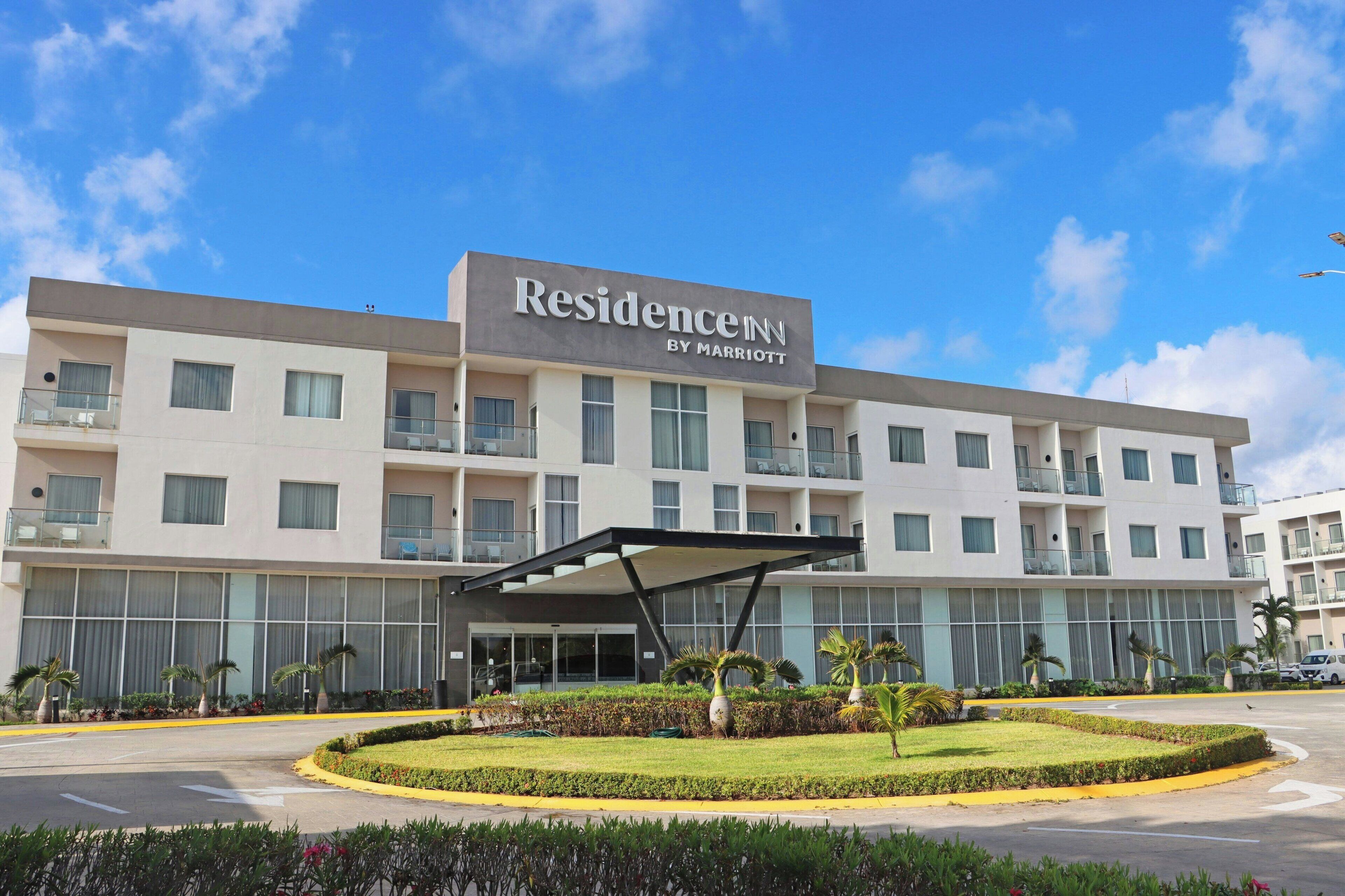 Een hotel met meerdere verdiepingen, met een groot bord waarop 'Residence Inn by Marriott' staat en een overdekte ingang.
