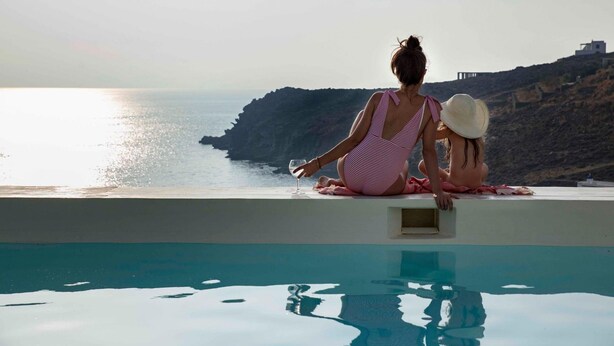 A person sitting by a pool with a view of the sea and a cliff. - Selene Villa With Private Pool and Sea View 96m (Tinos)