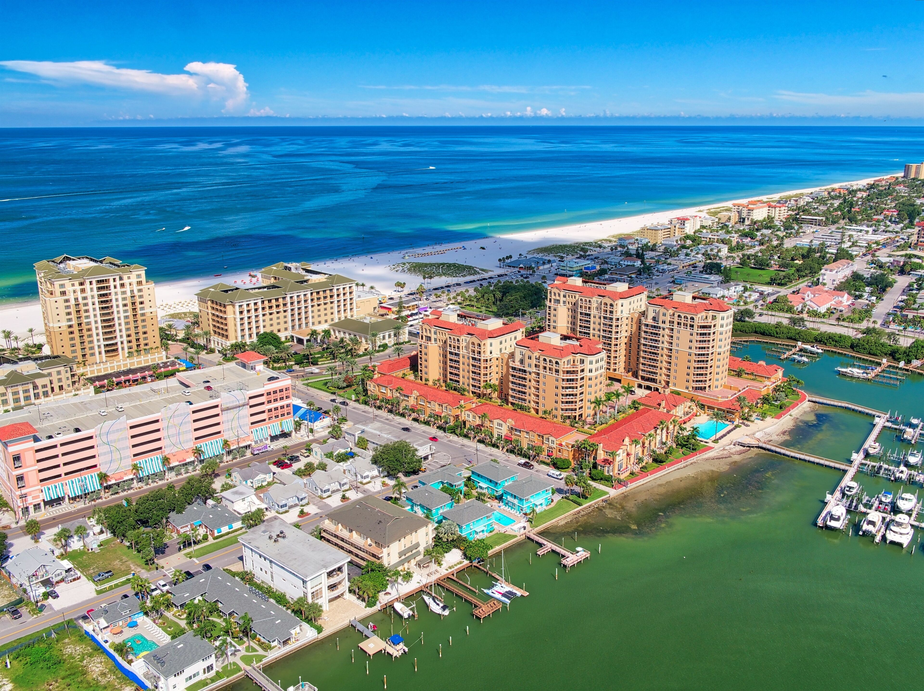Ein Küstenhotel mit mehreren Hochhäusern, einer Marina und einem Strand.