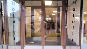 A hotel entrance with glass doors and a visible interior including a staircase and a reception area. - Hotelli Kerava (Kerava)