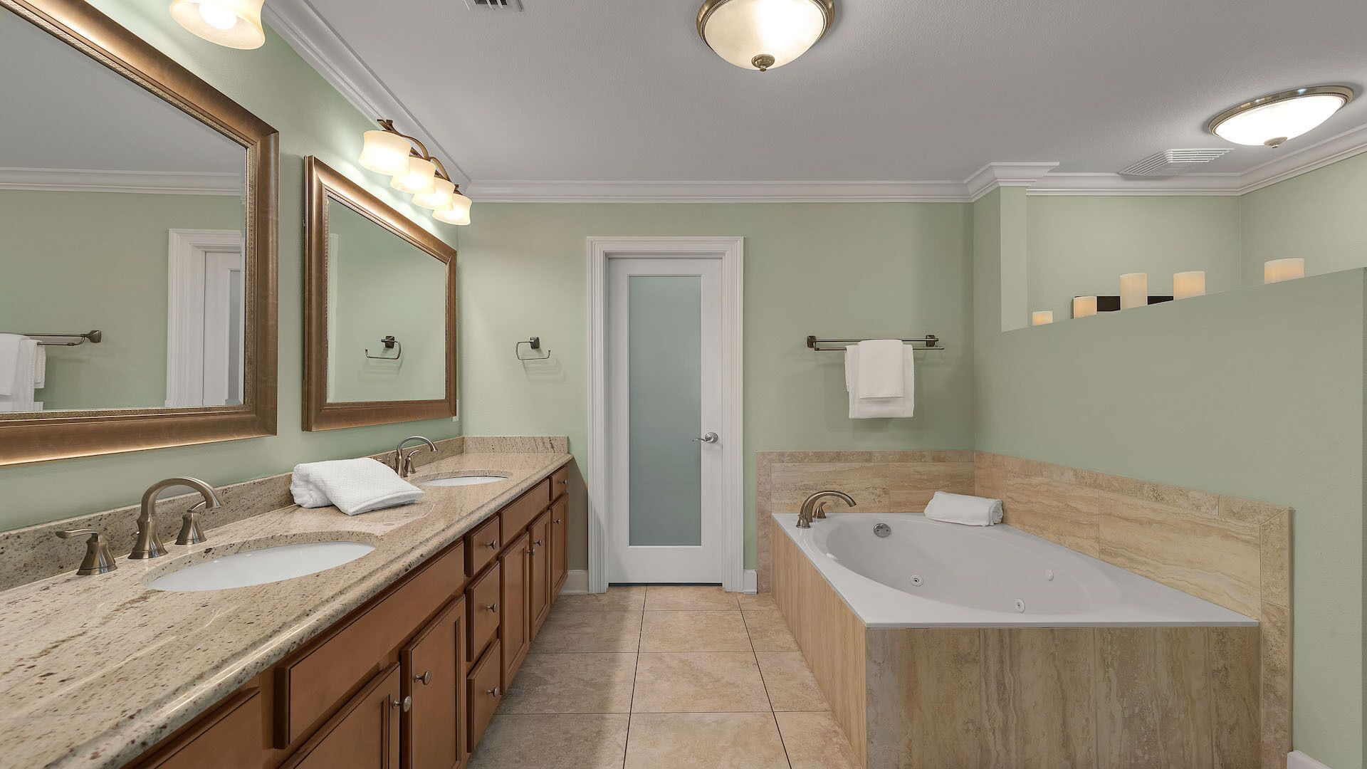 Une salle de bain avec deux lavabos, une baignoire et un grand miroir.