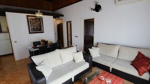 Una sala de estar con sofá, una mesa de centro y un comedor con mesa y sillas.