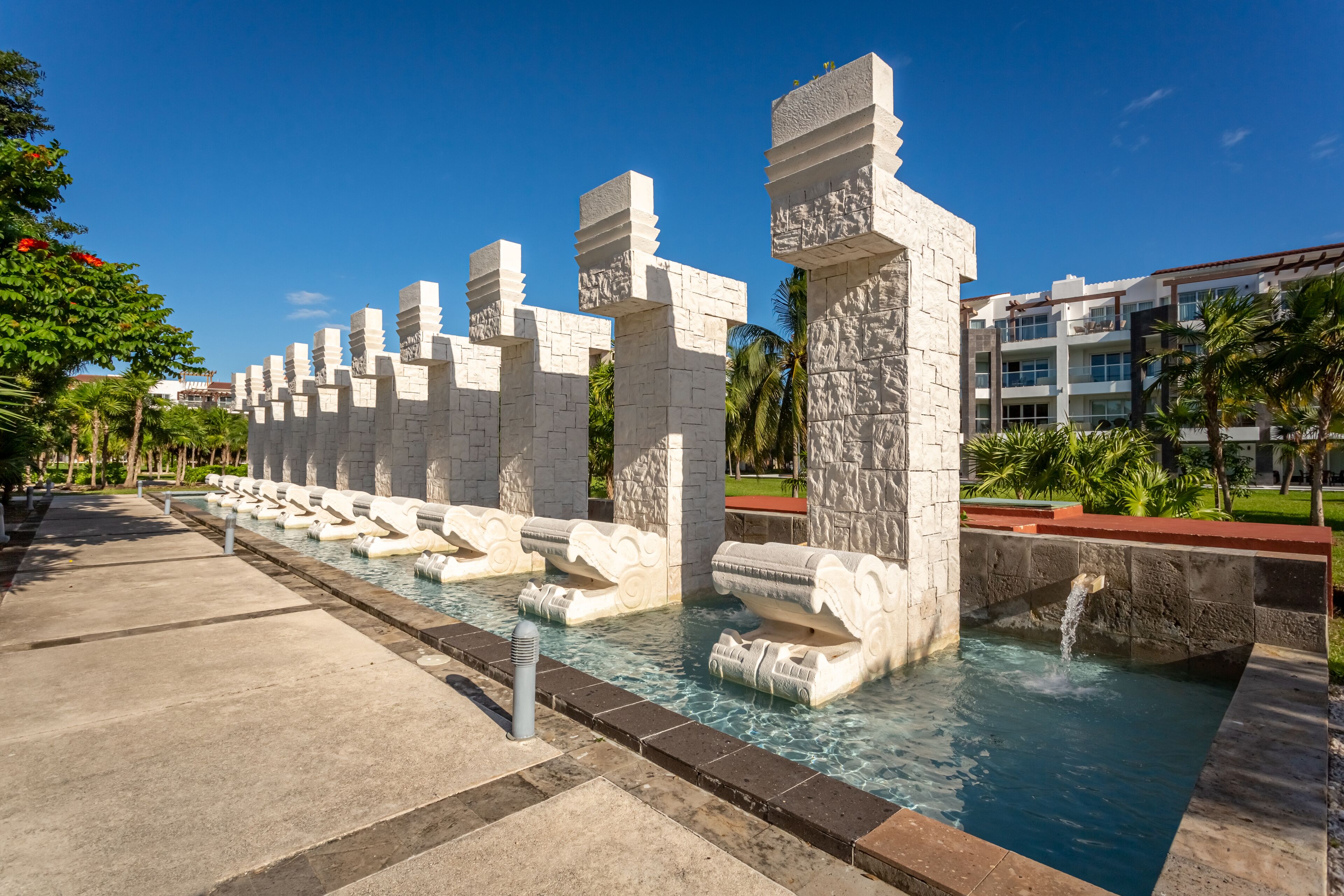 A water feature with stone sculptures, a pool, and a pathway.
