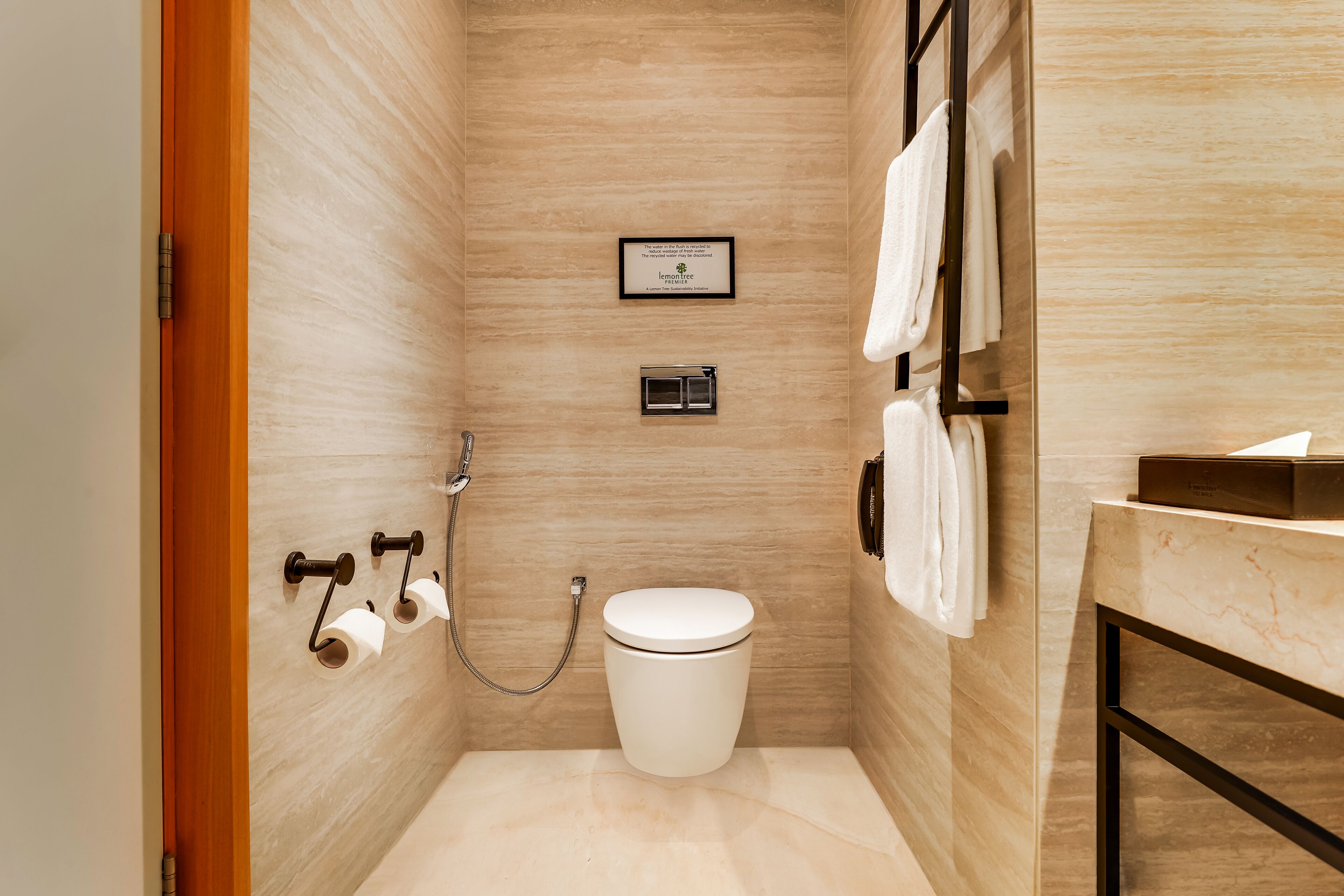 A modern bathroom with a toilet, a shower, and a towel rack.
