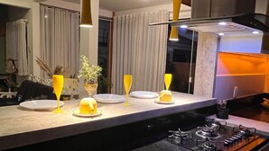 A modern kitchen with a black countertop, a gas stove, and pendant lights.