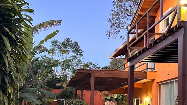 A modern house with a wooden deck, a covered patio, and a large window.
