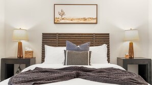 A bed with a wooden headboard, two bedside tables with lamps, a framed picture on the wall, and a blanket on the bed. - Casa del rancho in the EE - 3 km from FIFA Fest (Houston)