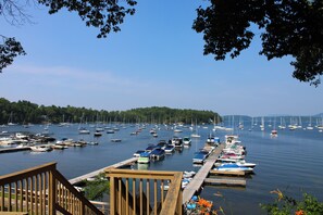 A marina with multiple boats docked, surrounded by trees and a clear sky. - Harbor View Lakehouse (Colchester)
