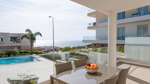 A modern outdoor dining area with a pool, overlooking the sea. - Stunning modern apartment [85] (Lagos)