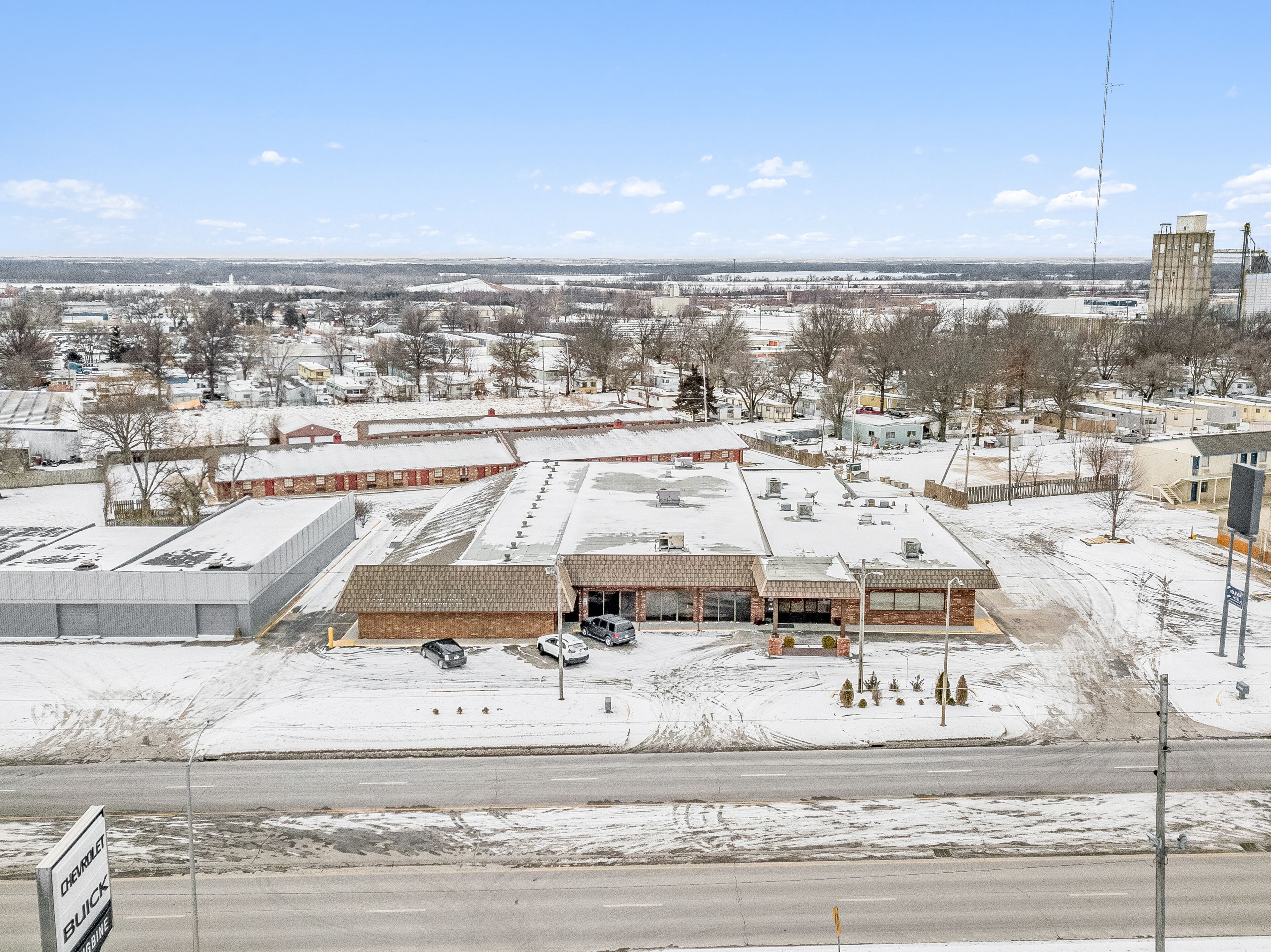 A large industrial building with multiple parking areas and a flat roof.