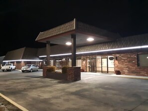 Un hôtel doté d’un parking couvert, d’une façade en briques et d’une entrée bien éclairée.