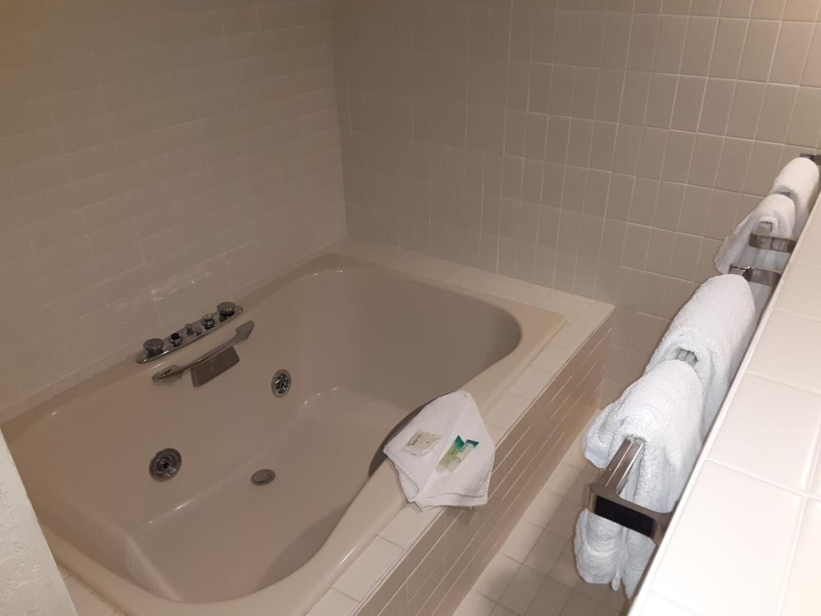 A bathroom with a bathtub, a towel rack, and a shower area.