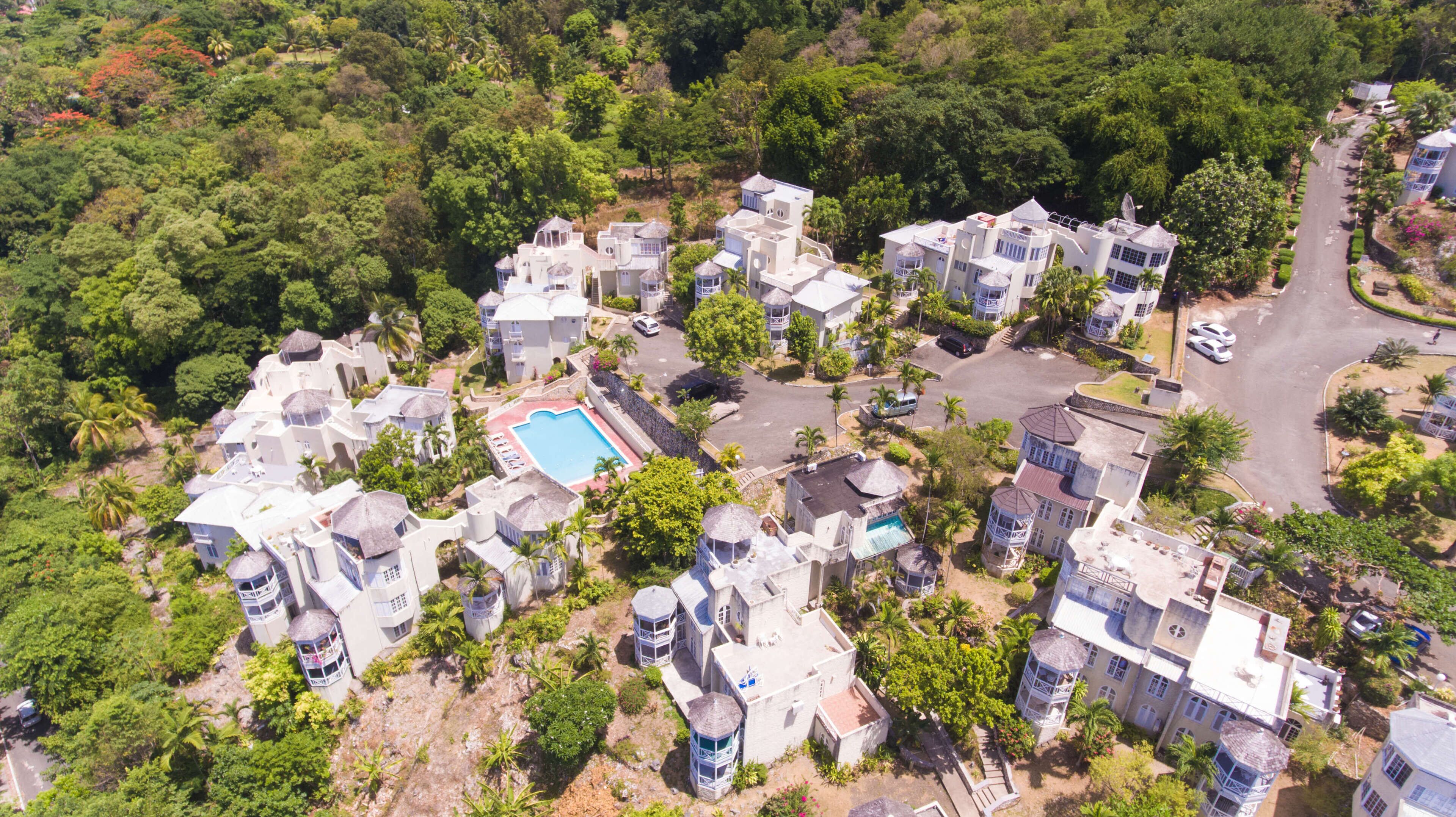 Une vue aérienne d’un quartier résidentiel avec plusieurs maisons, une piscine et une route.