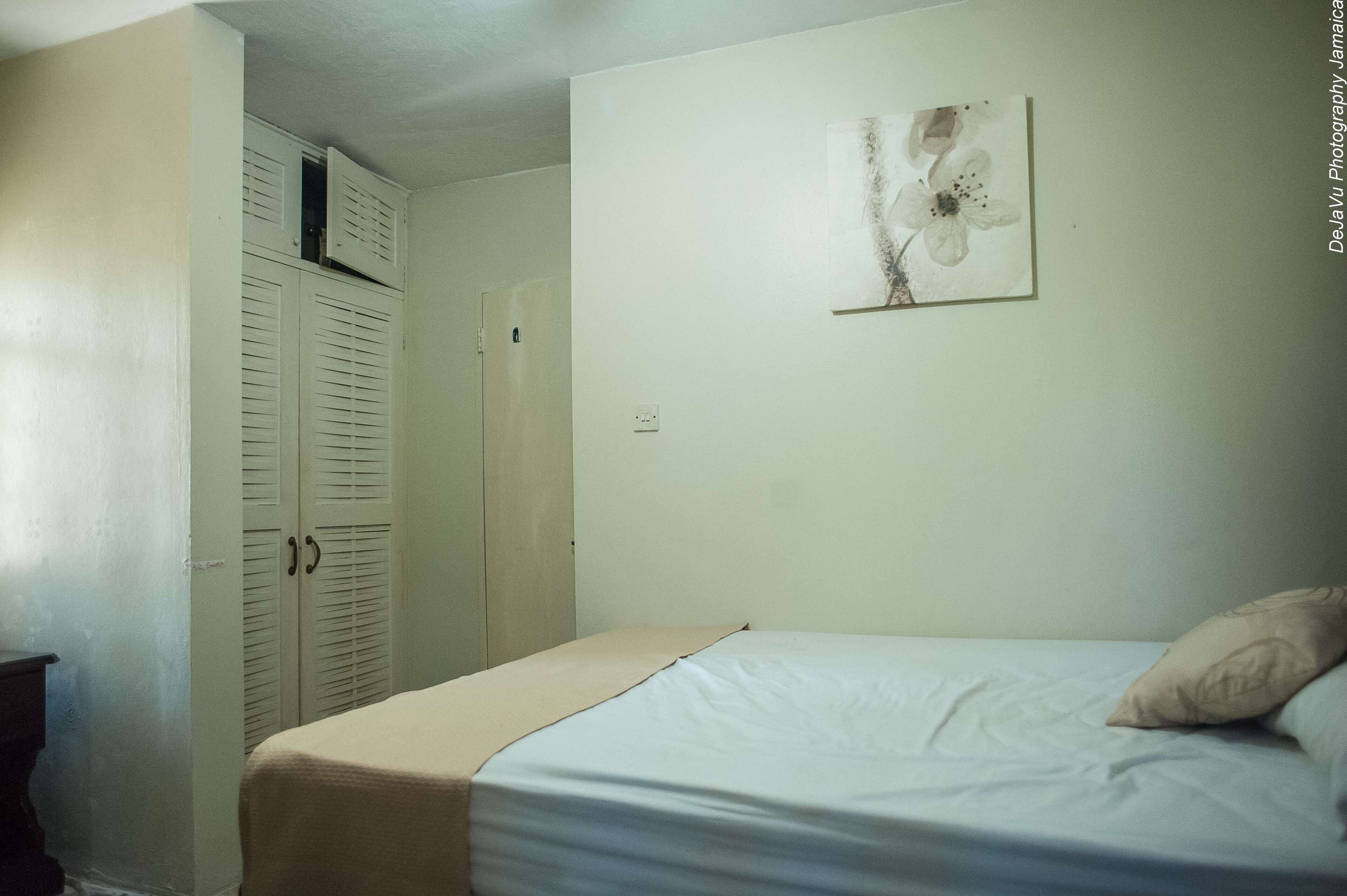 Une chambre à coucher comprenant un lit, une armoire et une œuvre d’art accrochée au mur.