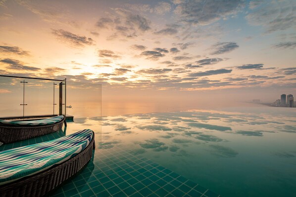 Una piscina al aire libre, sillones reclinables de piscina