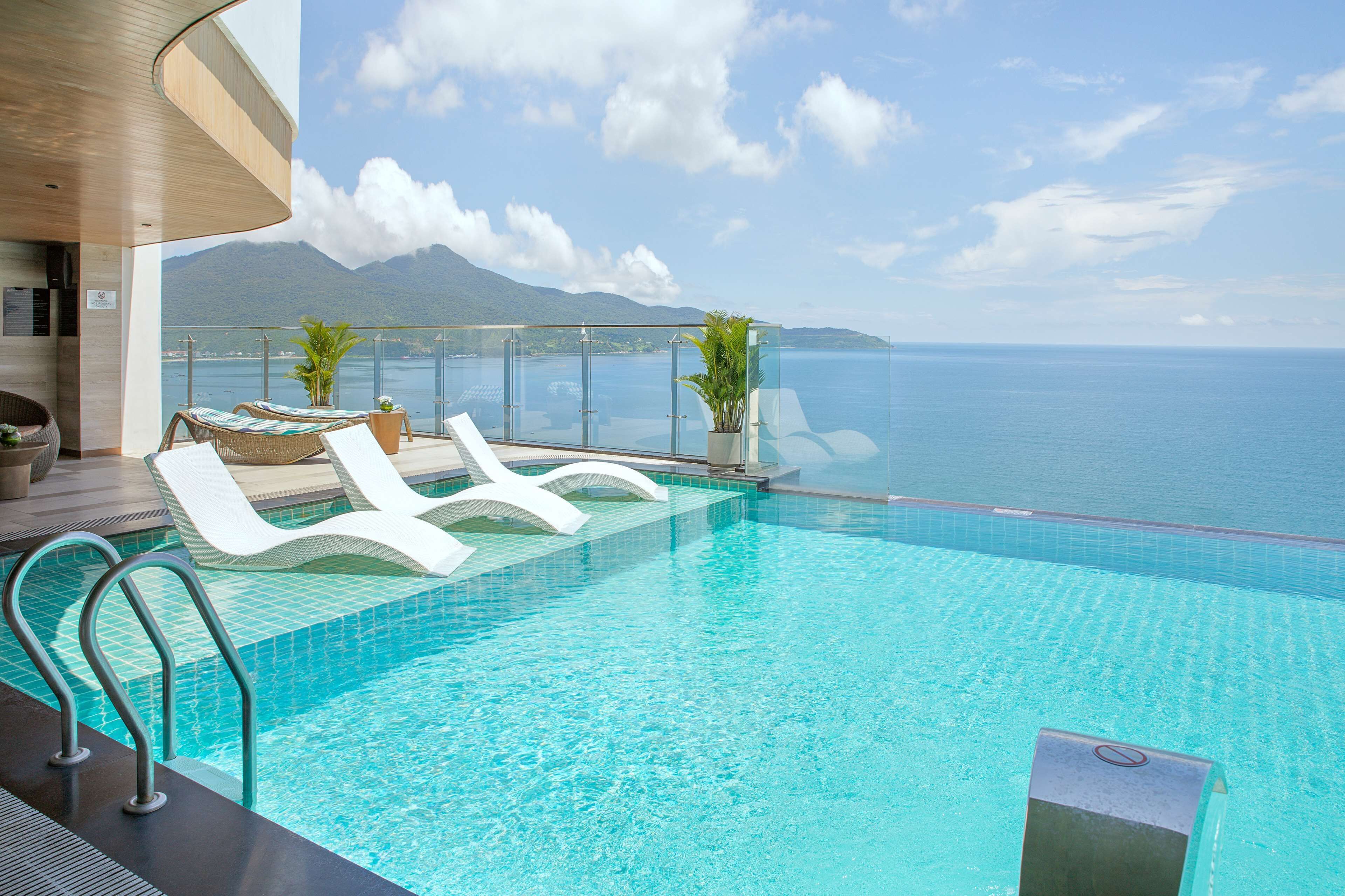 Una piscina al aire libre, sillones reclinables de piscina