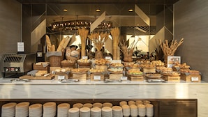 Ein Buffet mit verschiedenen Brotsorten und Gebäck auf Holztischen.