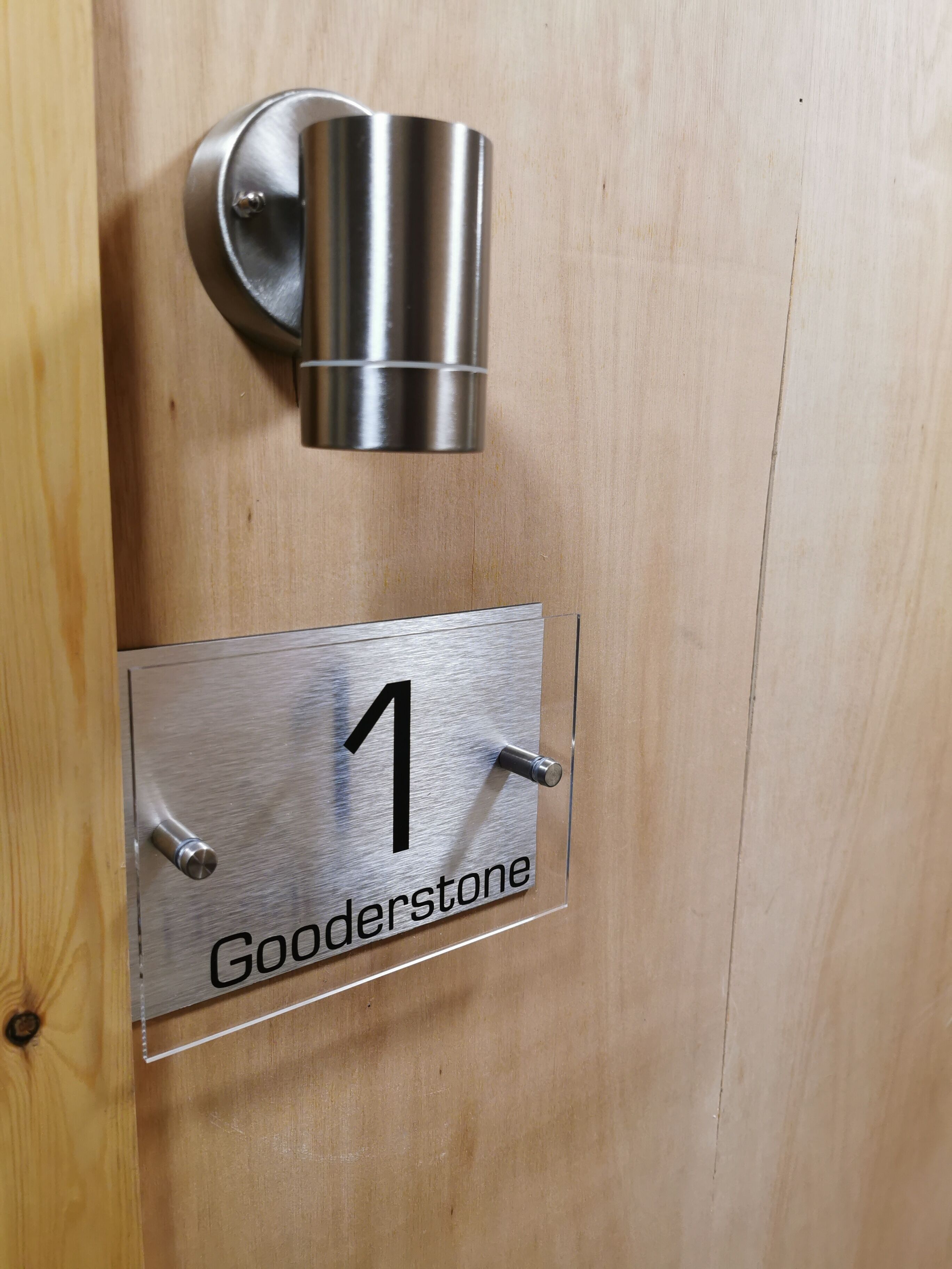 Eine Tür mit einem Metallschild, auf dem die Nummer 1 und der Name Gooderstone stehen.