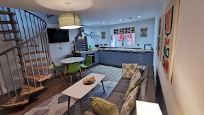 A modern apartment with a kitchen, dining area, and living room.