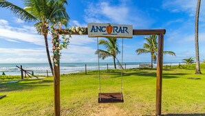A beach view with a swing set and a sign that reads "ANCORAR". - Ancorar mar-piscina em Porto de Galinhas (Ipojuca)