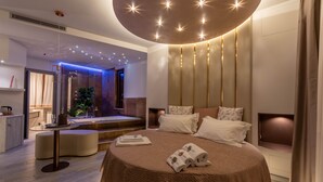 A modern hotel room with a round bed, a small sitting area, a vanity, and a shower area. - Beautiful Assisi Suite (Assisi)