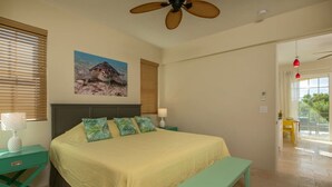 A bedroom with a bed, a nightstand, a bench, a ceiling fan, and a window with blinds.