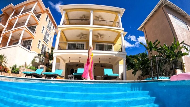 A multi-story building with a pool, balconies, and outdoor seating.