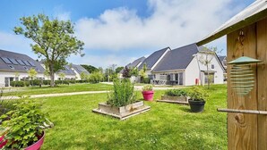 Een woonwijk met huizen, een verzorgd gazon en bloembedden.