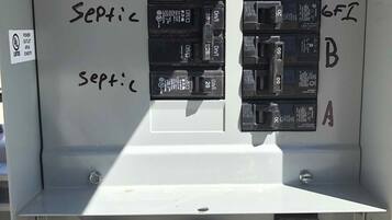 A utility panel with labeled switches and a warning sign.