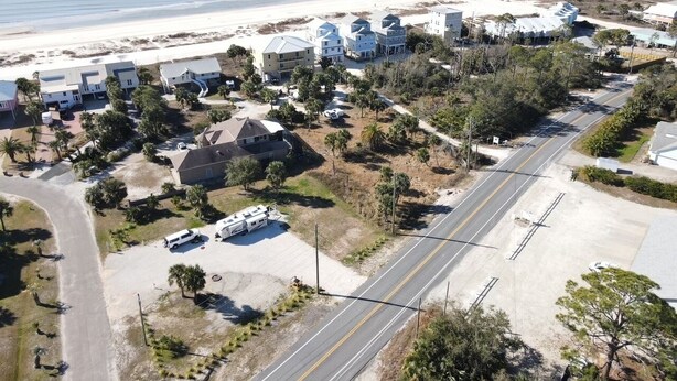 Vista aérea de una zona residencial costera con casas, una carretera y una playa.