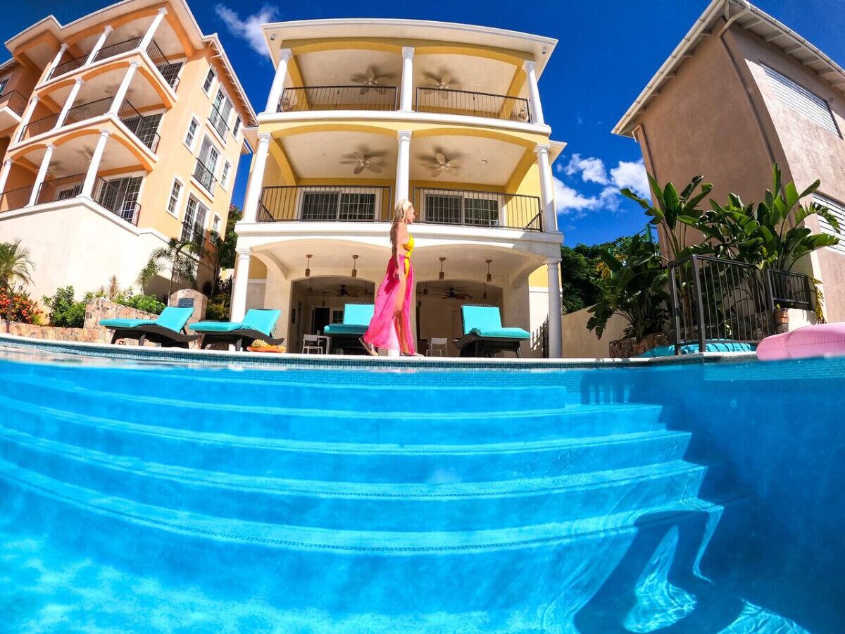 A multi-story building with a pool, balconies, and outdoor seating.