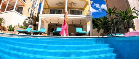 A multi-story building with a pool, balconies, and outdoor seating.