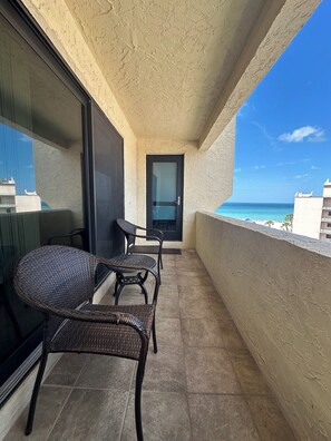 A balcony with wicker furniture, a door, and a view of the ocean. - PRIVATE BEACH ACCESS. WI-Fi , LOUNGER, PARKING. SIESTA KEY. #1 CRESCENT BEACH. (Sarasota)