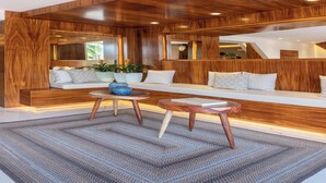 A modern living room with a wooden accent wall, a sofa, a coffee table, and a rug.