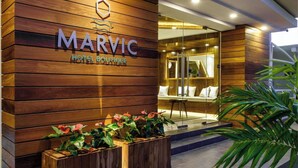 A hotel entrance with a wooden facade and a reception area visible through glass doors.