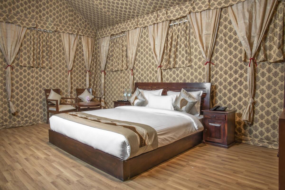 Un dormitorio amplio con una cama grande, cabecera de madera y mesitas de noche a juego.