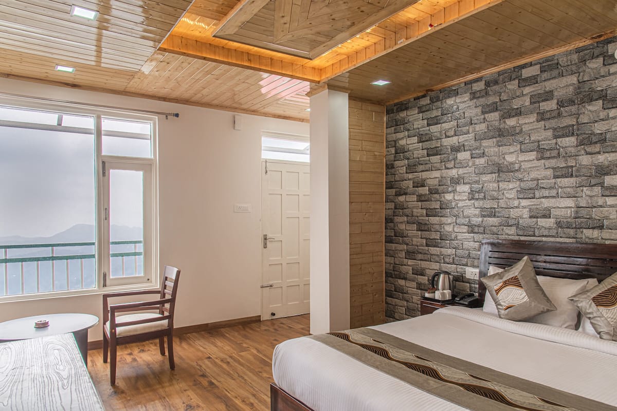 Un dormitorio con cama, techo de madera, pared de piedra y ventana con vistas.