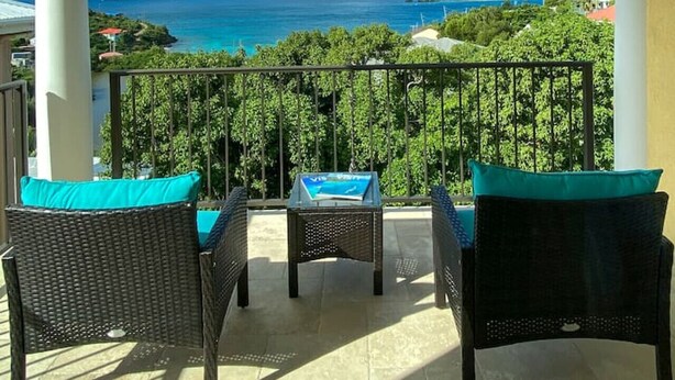 A balcony with wicker furniture and a view of the sea. - Allamanda 3 - 1 bedroom suite at Seagrape Vista (Cruz Bay)