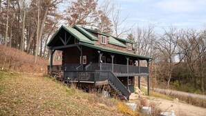 A rustic cabin with a green roof, wooden exterior, and a balcony. - 2-bedroom vacation home just 10 minutes from Viroqua's charming downtown (Viroqua)