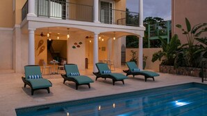 Un espace aménagé au bord de la piscine, avec des chaises longues et un coin salon abrité.