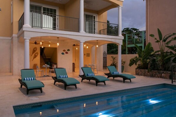 Un espace aménagé au bord de la piscine, avec des chaises longues et un coin salon abrité.