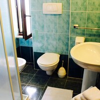 Un baño con inodoro, lavamanos y ventana.