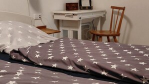 A bedroom with a bed, a desk, a chair, and a lamp. - Ferienwohnung Boger (Wannweil)