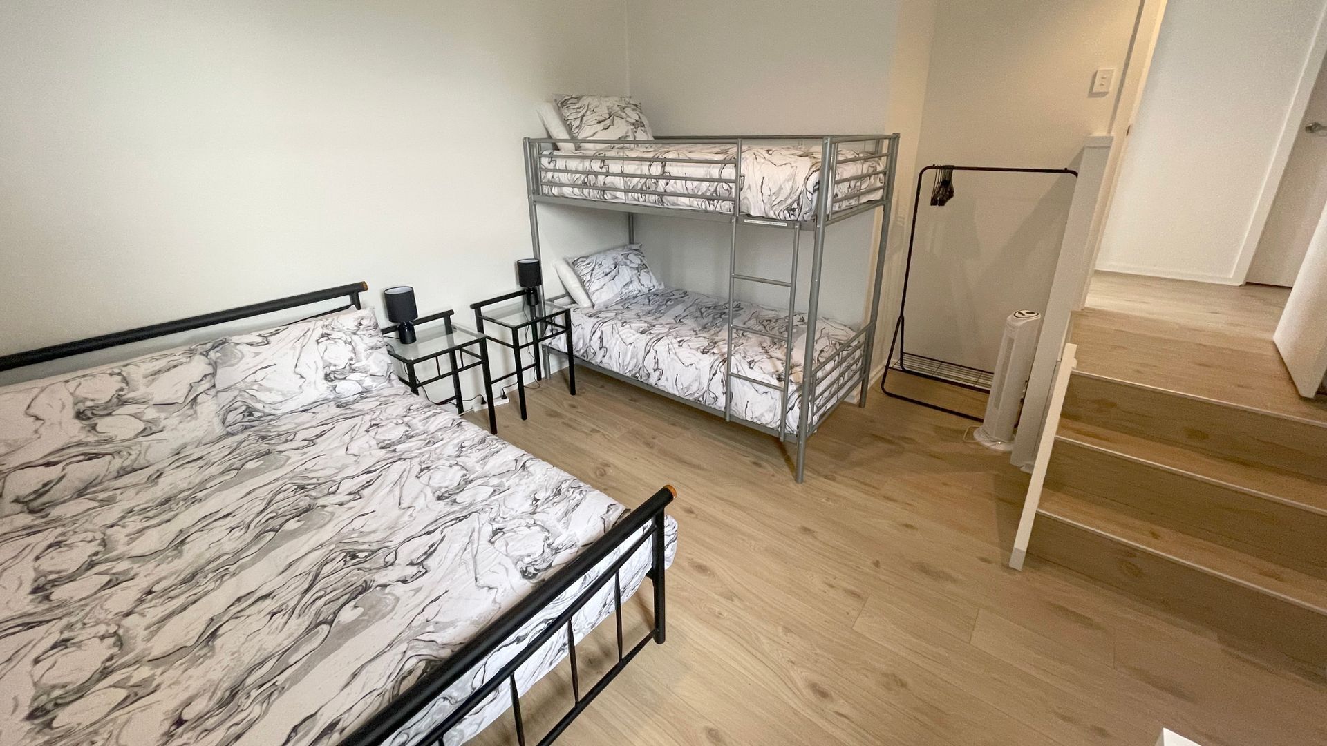 Een studentenkamer met een stapelbed, een bureau en een stoel.