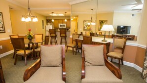 A hotel room with a dining area, a television, and a large mirror. - 2022 Dec23-30 2 BD/2BA 0.8 mi to Disney World at Cypress Pointe Resort (Orlando)