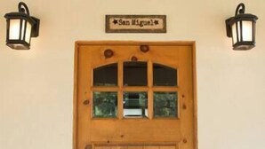 A wooden door with a glass window and a sign above it. - San Miguel Suite at Blanco Rapids Ranch (Wimberley)