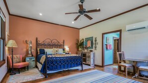 A bedroom with a bed, a ceiling fan, a dresser, a chair, and a mirror. - San Miguel Suite at Blanco Rapids Ranch (Wimberley)