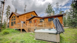 A wooden cabin with a hot tub, deck, and a view of the surrounding forest. - Royal Aspen Retreat Home: Lovely Setting, Spacious (Breckenridge)